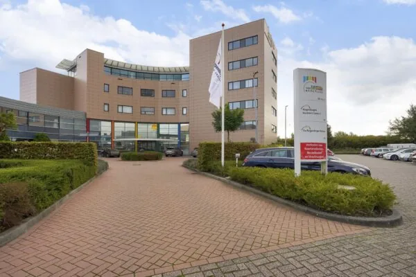 Vooraanzicht van het Regenboog Business Center aan de Laan van s-Gravenmade met parkeerterrein en een informatiebord.